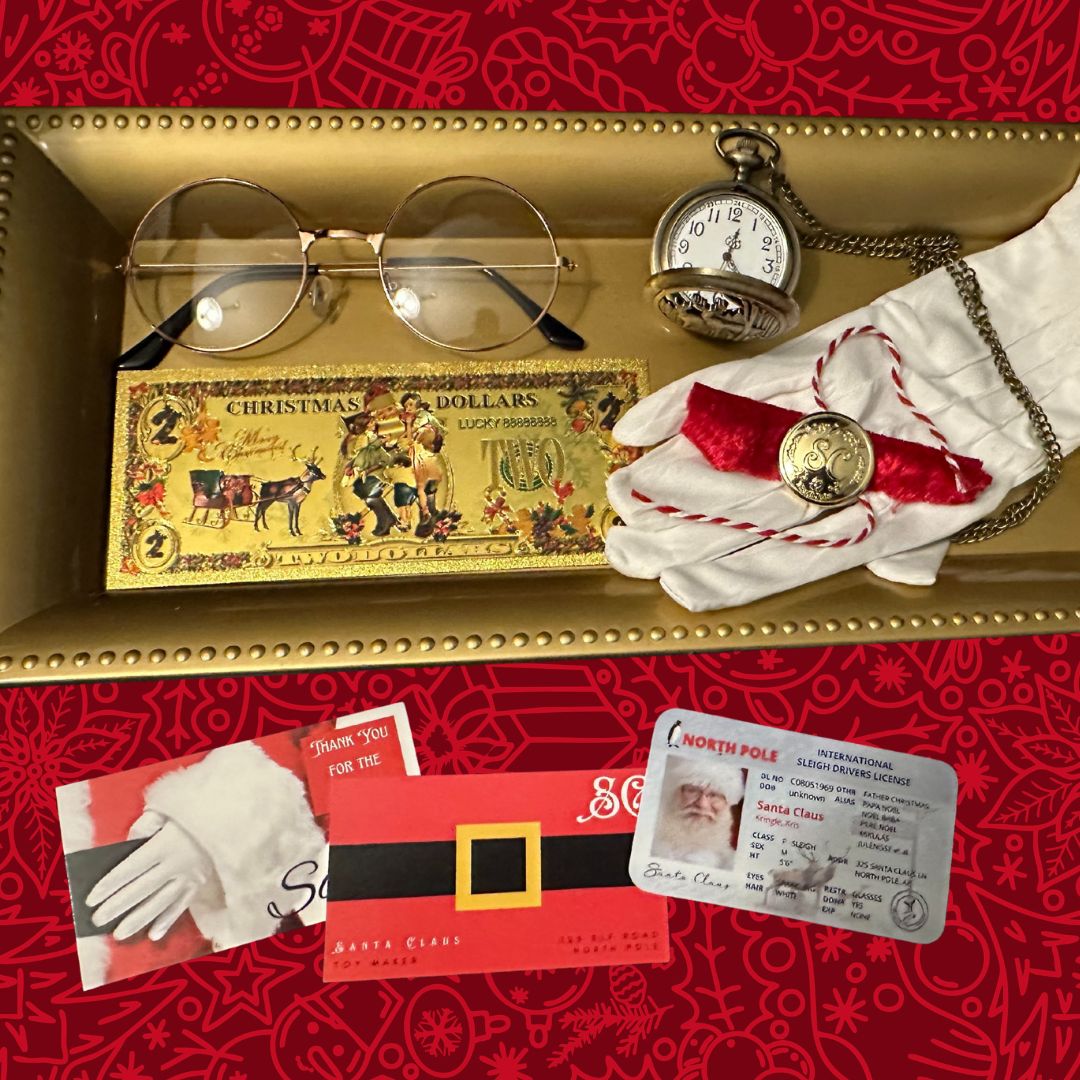 santas evidence kit with pocket watch, glove, brass button, $2 christmas dollars, sleigh license and business cards on a gold tray and red velvet holiday background